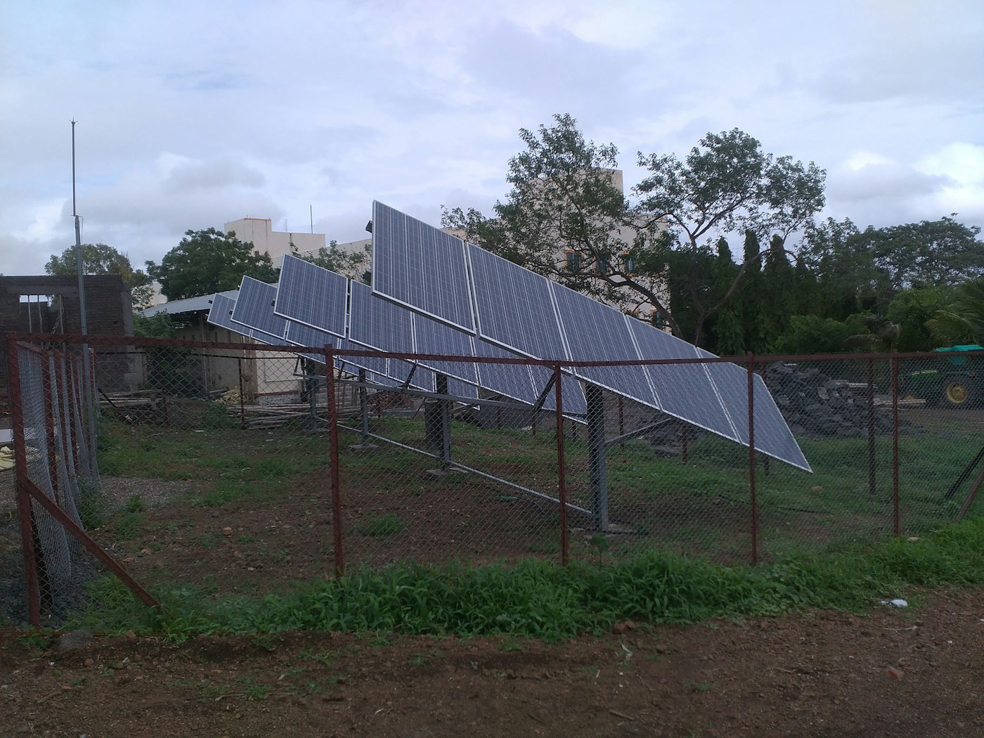 Solar panels mounted above a structure amid greenery in India